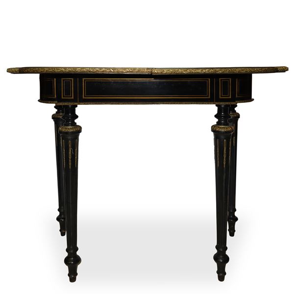 Folding and rotating boulle game table in black ebonized wood with gold details and fluted column legs equipped with casters. 
