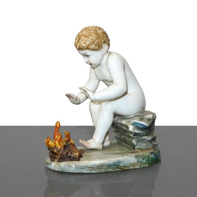 Bambino davanti al fuoco, statuetta in porcellana policroma