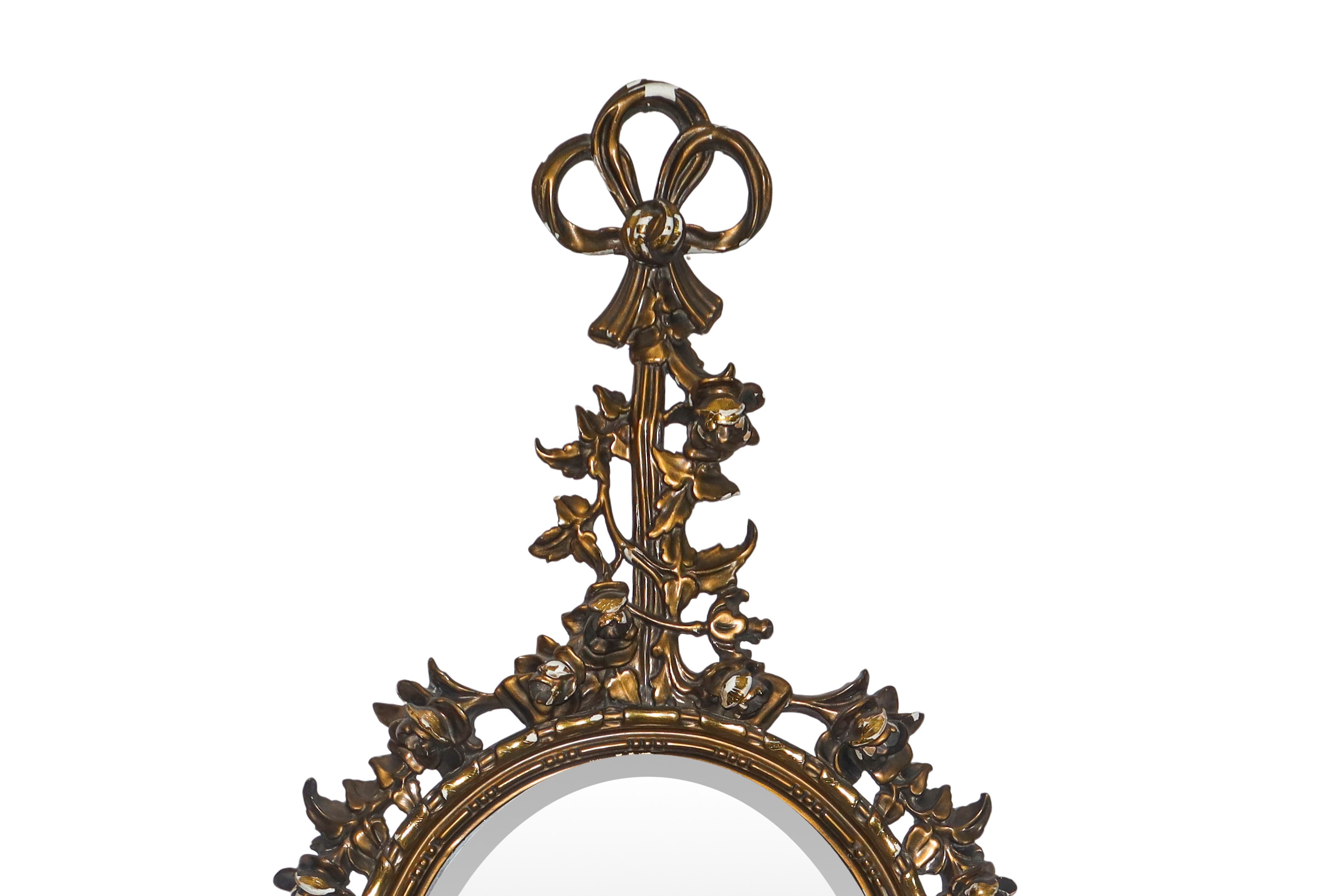 Specchiera ovale entro cornice dorata con decori floreali e fiocchi pendenti alla sommità e alla ...