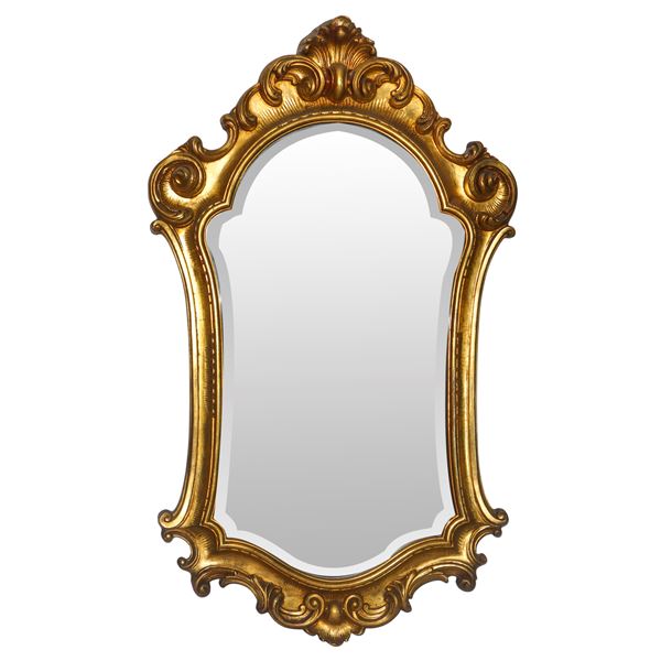 Specchiera sagomata entro cornice dorata decorata alla sommità e alla base con con spirali d'acanto