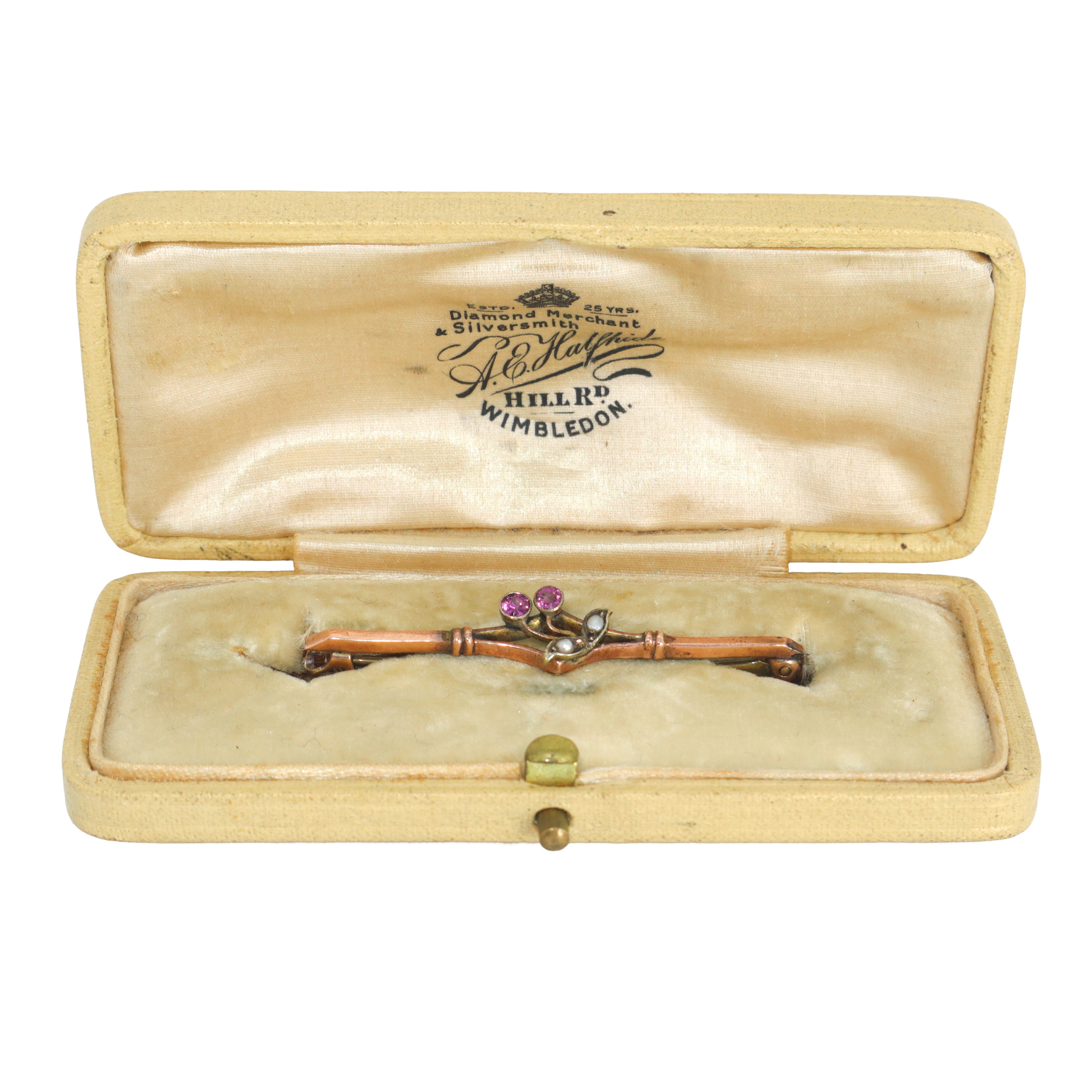 Spilla in oro a basso titolo con ciliegia sul fronte decorata da perline e pietre