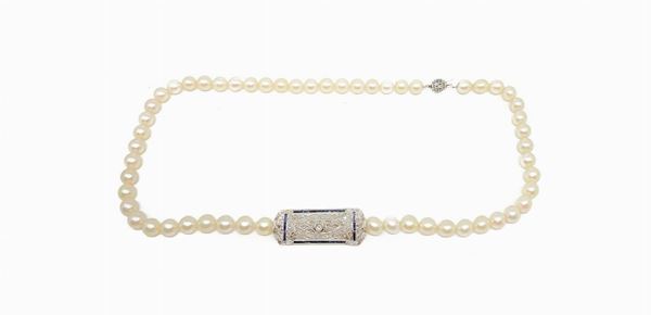 Collana di perle 8.3, chiusura con spilla decò aggiunta e removibile, ca 6 gr. Brillante centrale 8/8 e rosette di diamanti con contorno di zaffiri sintetici.  