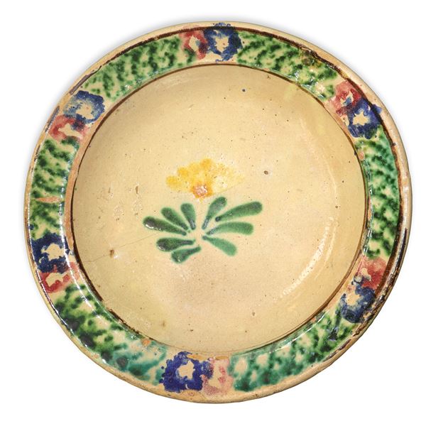 Piatto in maiolica di Caltagirone con bordo spugnato e fiore policromo al centro
