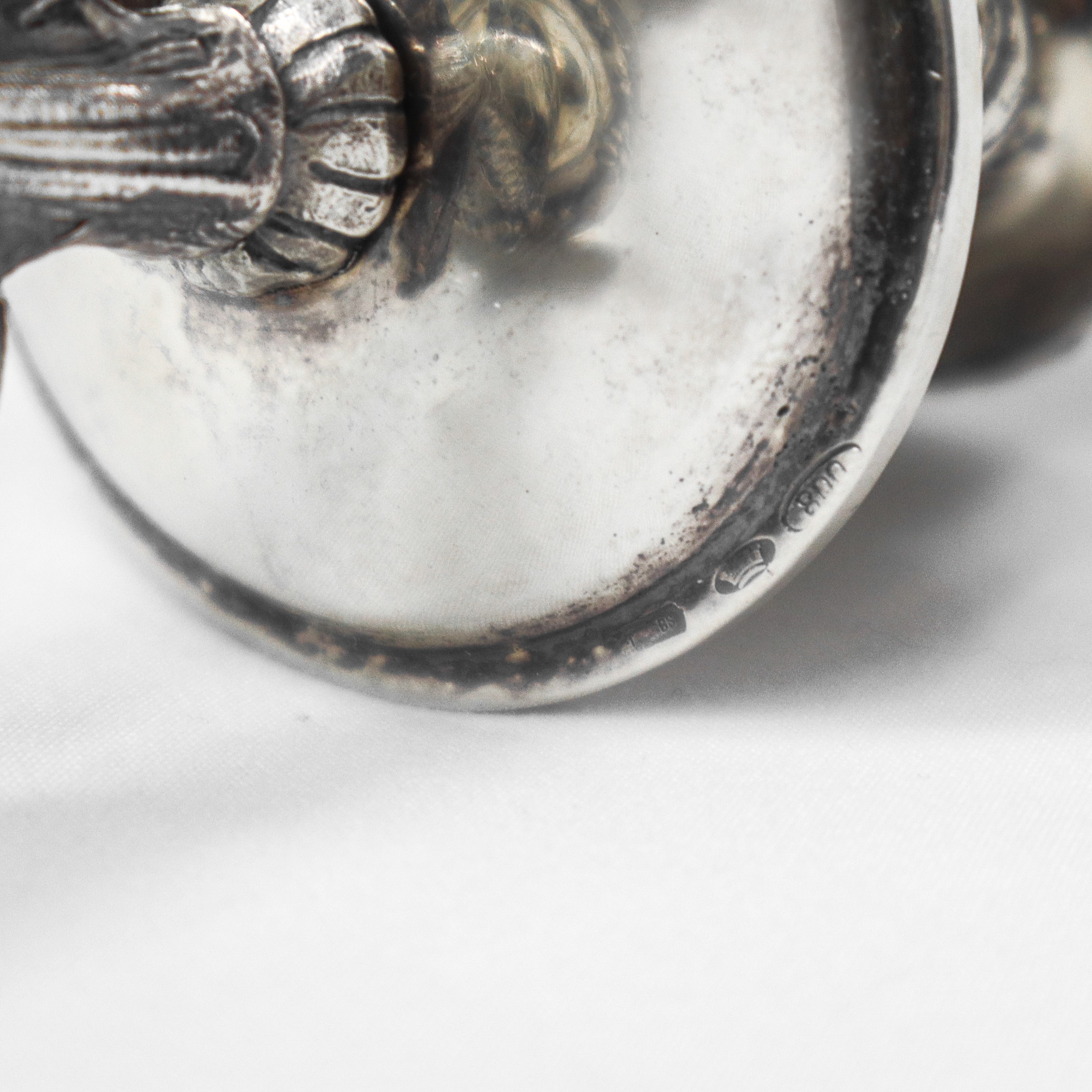 Coppia di candelieri monoforo con tritone alla base