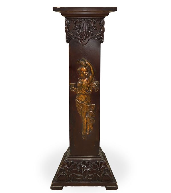 Carved wooden column with floral motifs at the base and a classical figure at the front