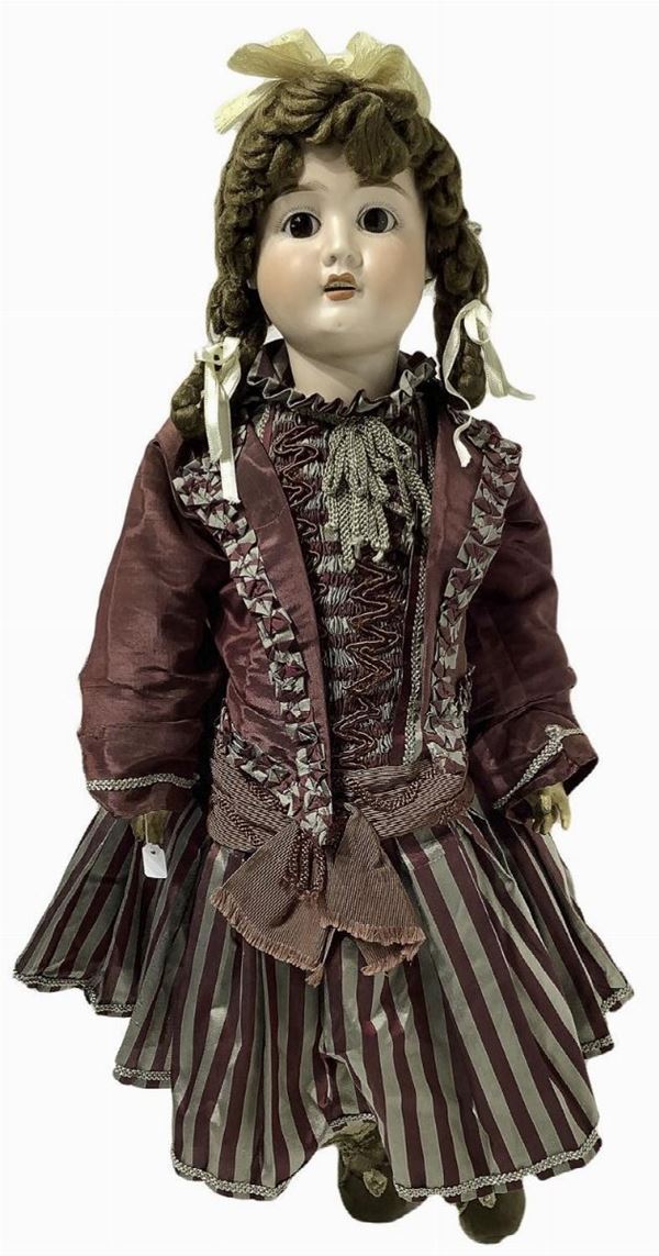 Doll in biscuit porcelain and body in composite material, claret striped dress, burgundy jacket with bows, bow head, brown mohair hair, beige shoes with bead, ankle strap with cord, eyes, n. 4 teeth, movable limbs, signed S. H., 1900 about, Germany origin, h 63 cm