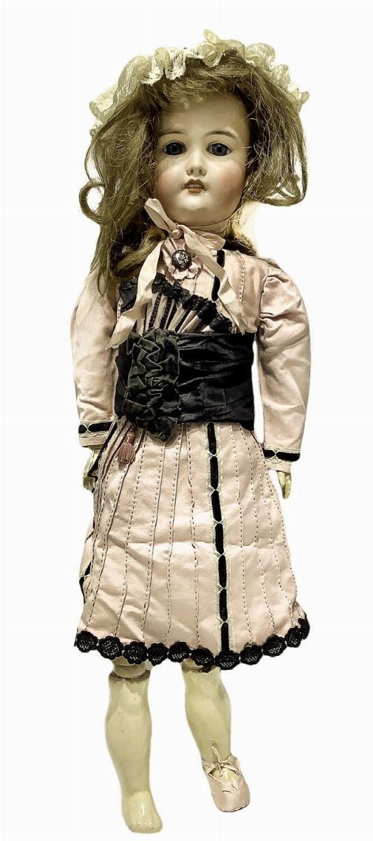 Bambola in biscuit e corpo in materiale composito, abito rosa con decoro in pizzo e cintura nera, capelli veri castani, occhi fissi, n. 4 dentini, arti di tipo tedesco snodati, firma CL 165 K 12 Germany, 1900 ca, provenienza Germania, leggera allentatura dell'elastico, mancante di una scarpetta destra, scarpetta sinistra rosella, h cm 76