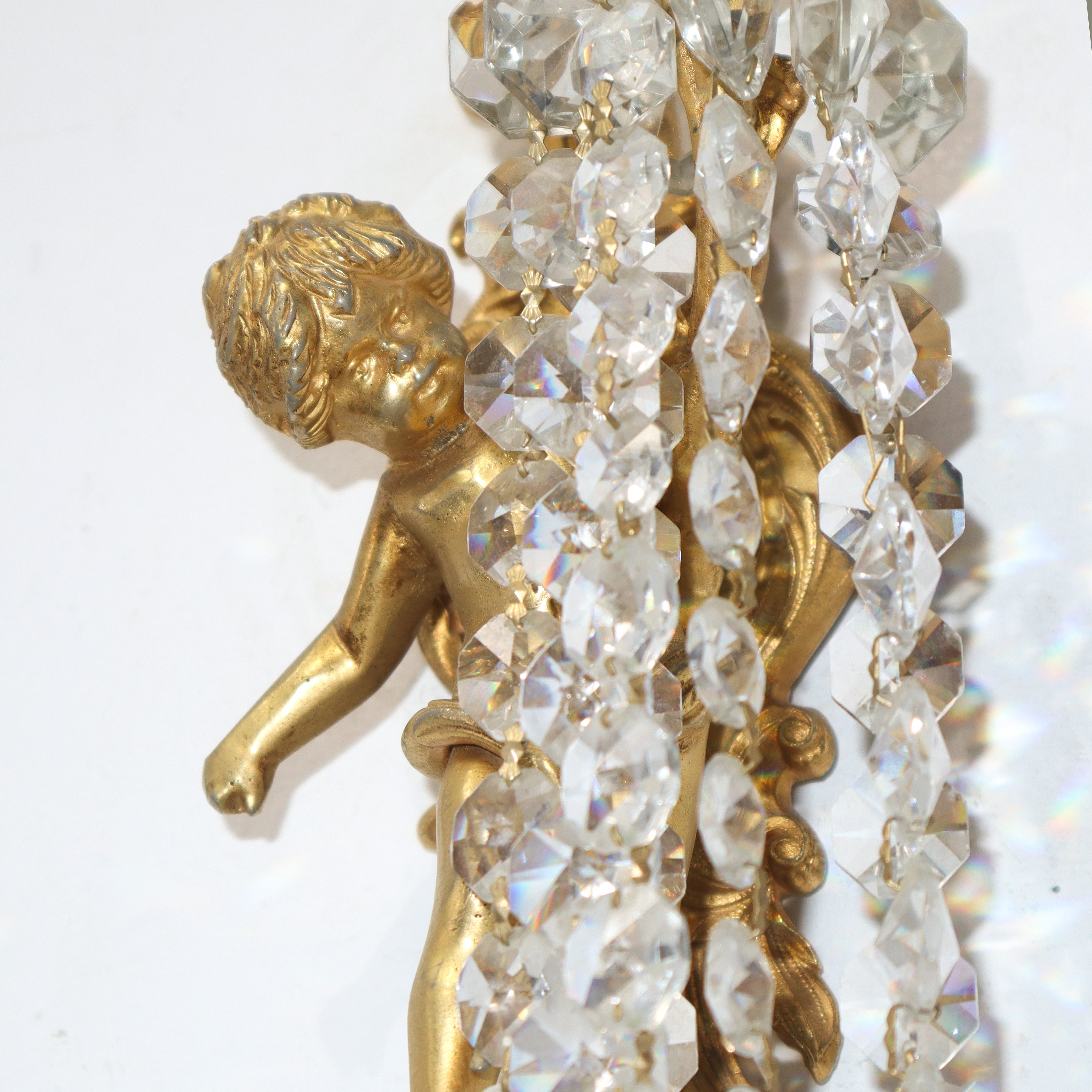 Coppia di appliques dorate a una luce a guisa di putto