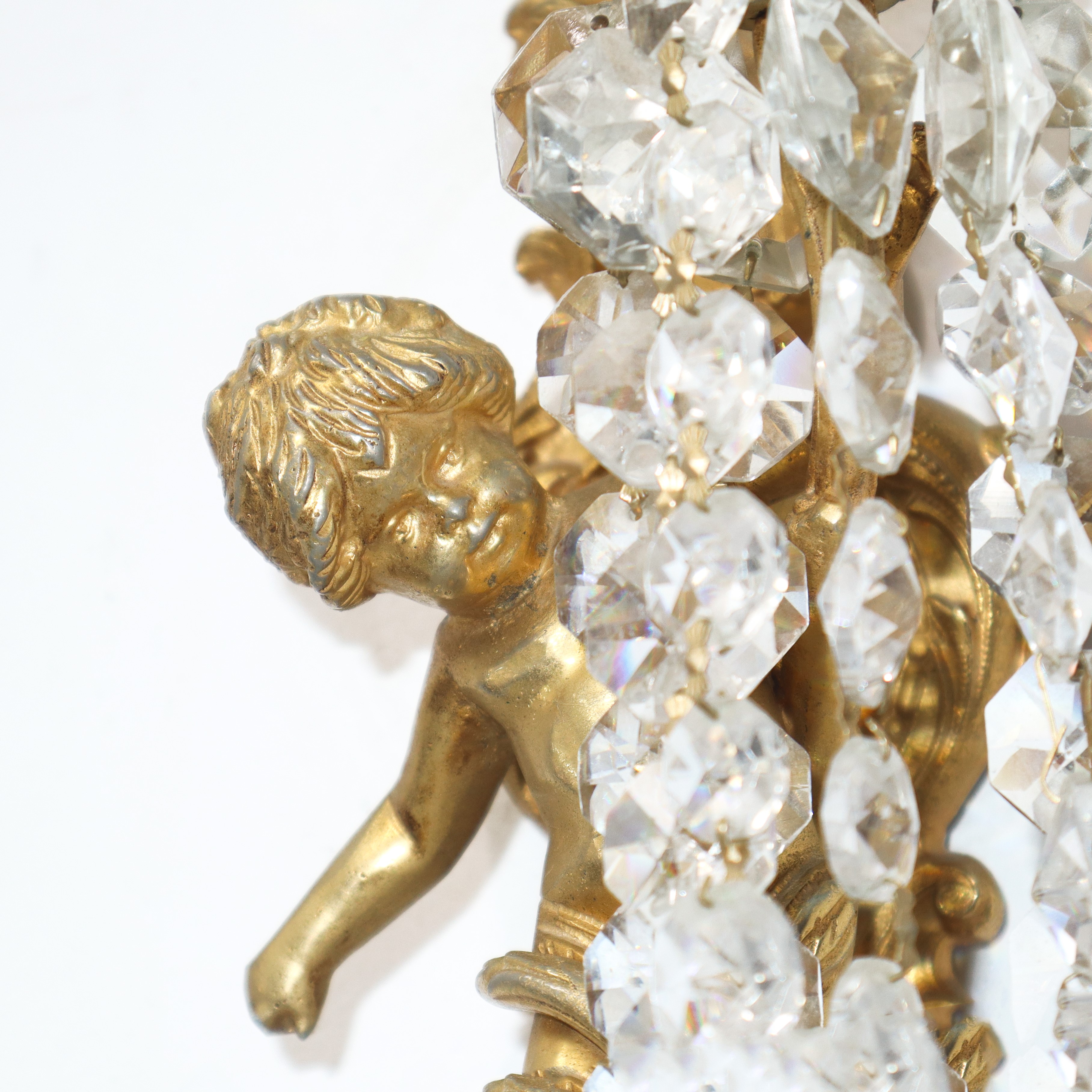 Coppia di appliques dorate a una luce a guisa di putto
