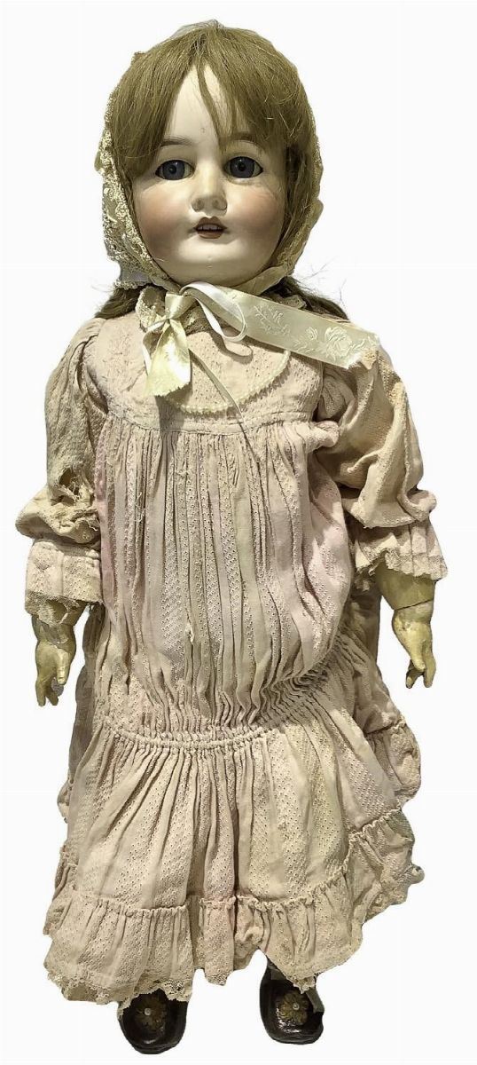 Bambola in biscuit e corpo in materiale composito, abito rosa con cuffietta panna, capelli veri, occhi fissi, n. 4 dentini, arti mobili, firma MON TRESOR, 1900 ca., provenienza Francia, h cm 68, leggere scrostature sulla guancia, 3 dita rotte
