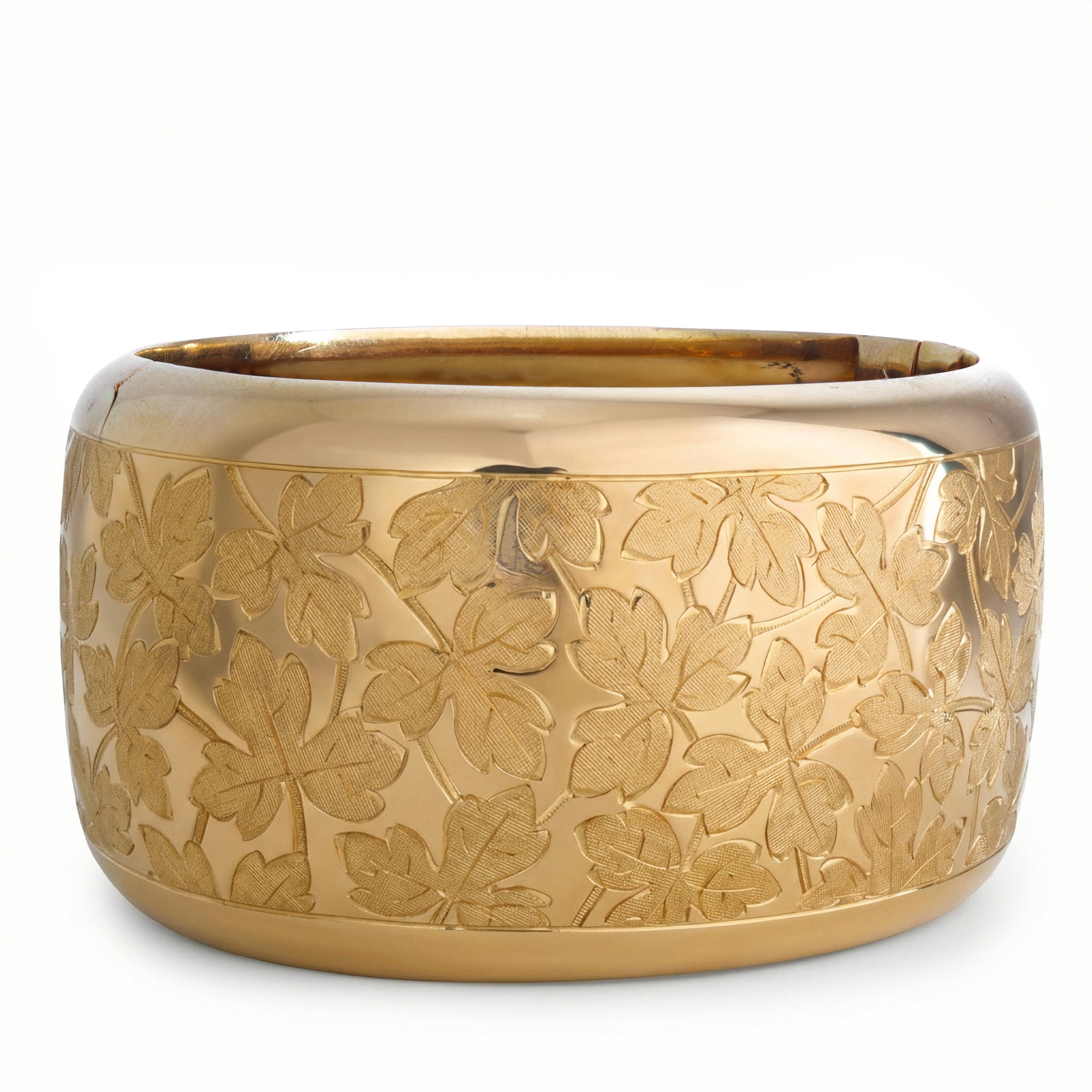 Bracciale rigido in oro giallo con decoro di trifogli satinati lungo tutto il corpo del bracciale...