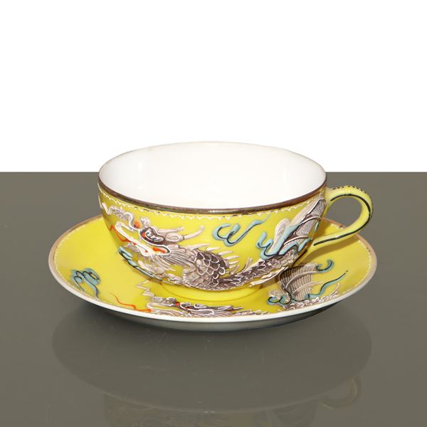 Yellow Japanese porcelain cup with saucer featuring embossed decorations