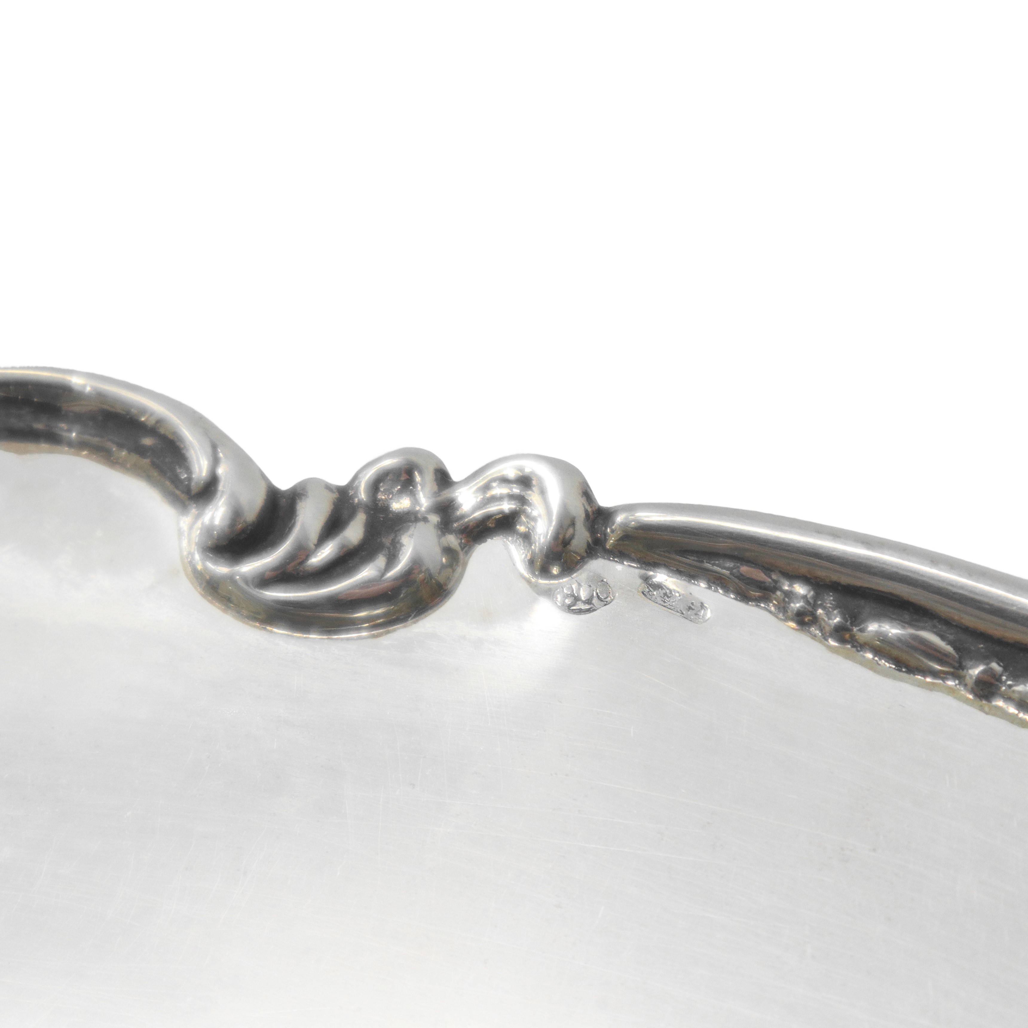 Piatto centrotavola in argento 800 con bordo decorato a volute