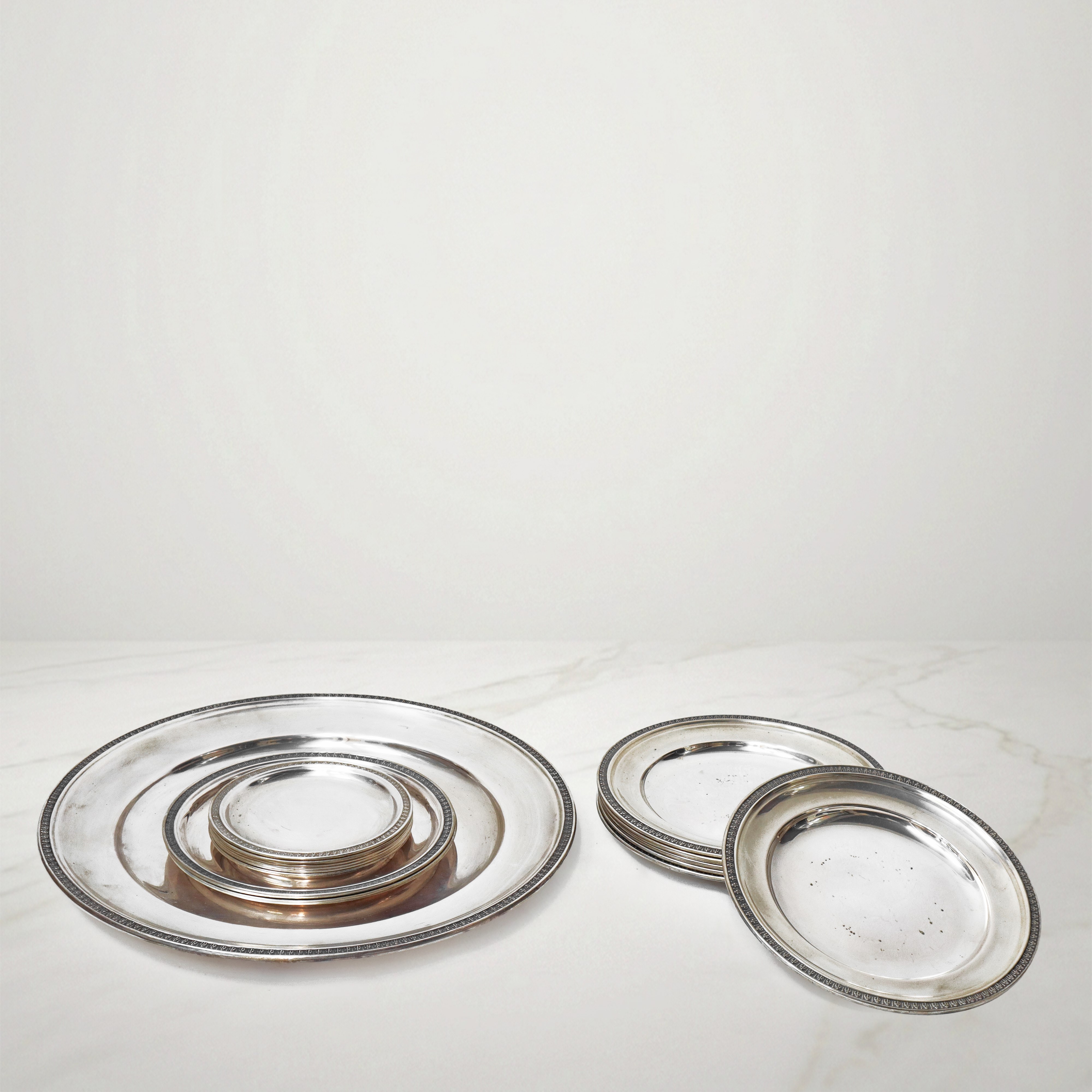 Set di piatti in argento 800 di vari formati decorati con foglie lanceolate