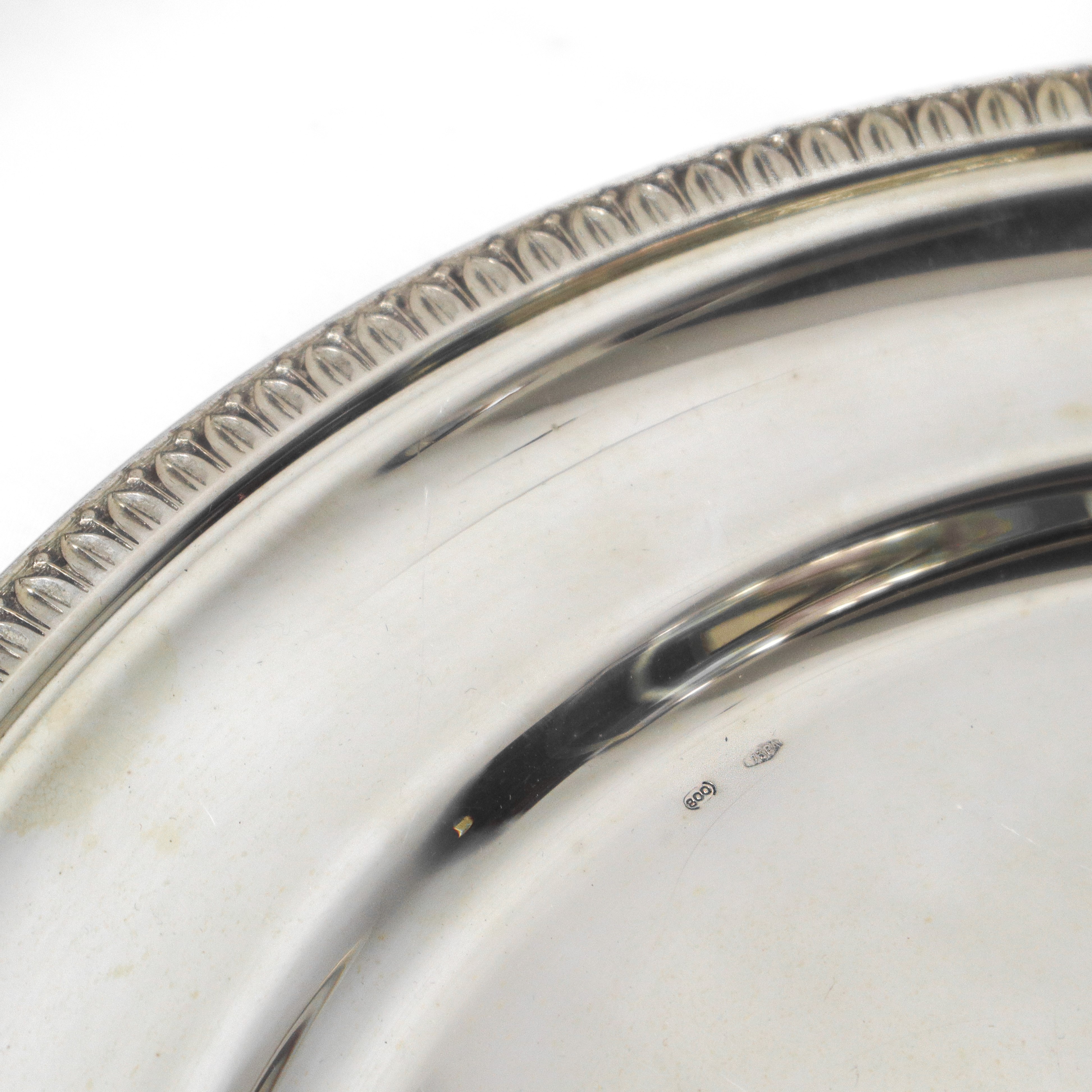 Piatto in argento 800 con bordo decorato a foglie lanceolate