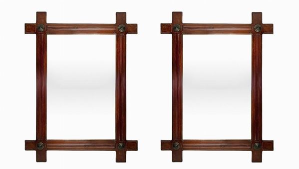 Coppia specchiere. Inizi XX secolo,in legno di mogano con borchie agli angoli in metallo brunito, inizi XX secolo