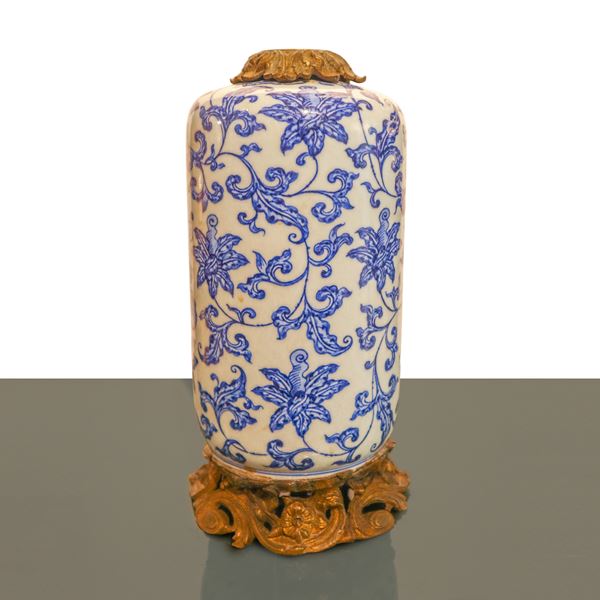 A Chinese blue and white Tsinghua porcelain vase with floral decoration mounted on a bronze base.