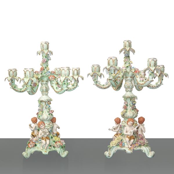 Coppia di candelabri a 7 luci in porcellana tedesca policroma con putti suonatori e tralci di fiori rampicanti