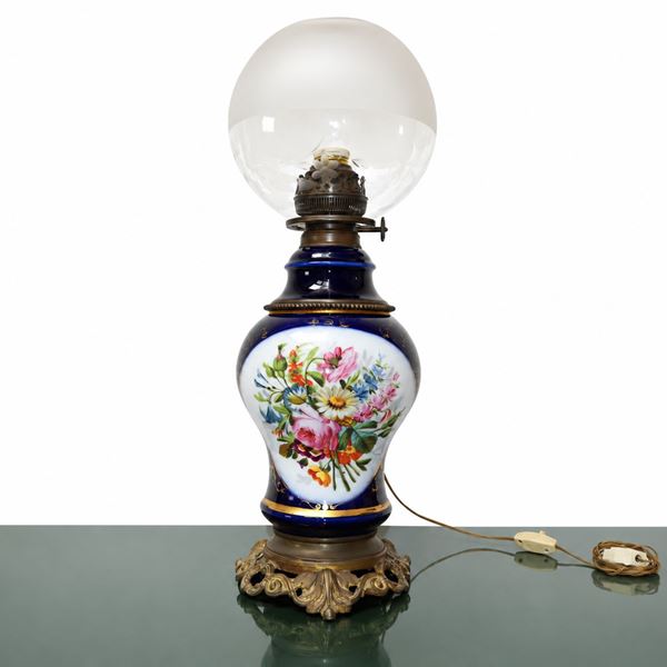 Electrified oil lamp in blue porcelain with floral decoration and ball-shaped bowl also decorated with floral motifs