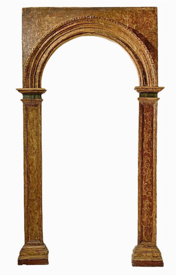 Arco in legno con lesene, in oro e decori. 