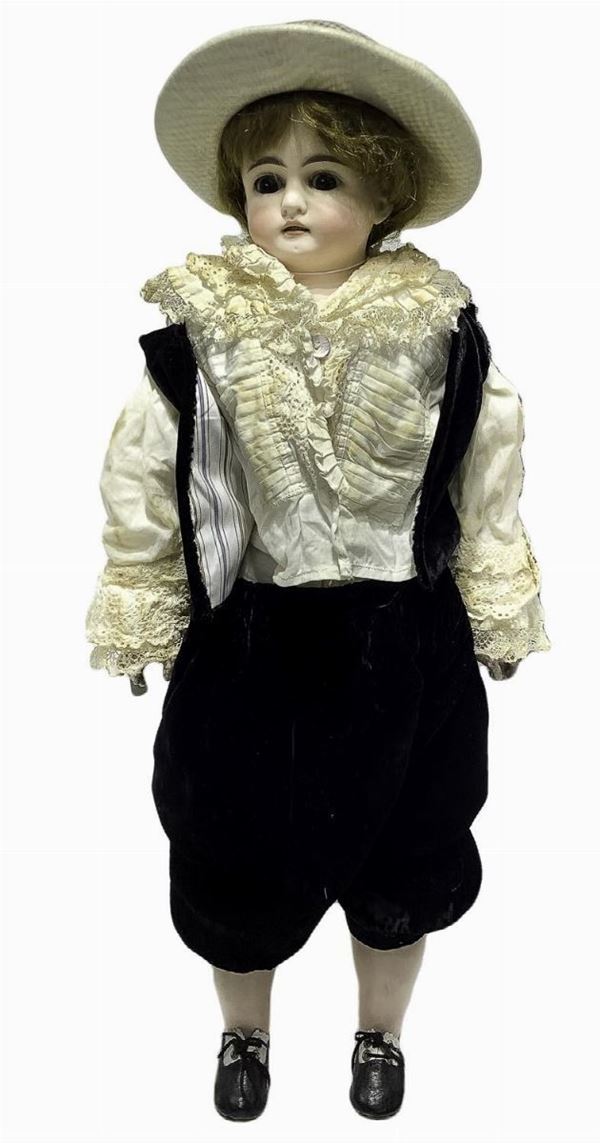 Bambola in biscuit e tessuto, pantalone e giacca in velluto nero, camicia color panna capelli veri, occhi fissi, n. 6 dentini, arti mobili,  1880 ca., provenienza Germania, h cm 55, macchie sulla camicia