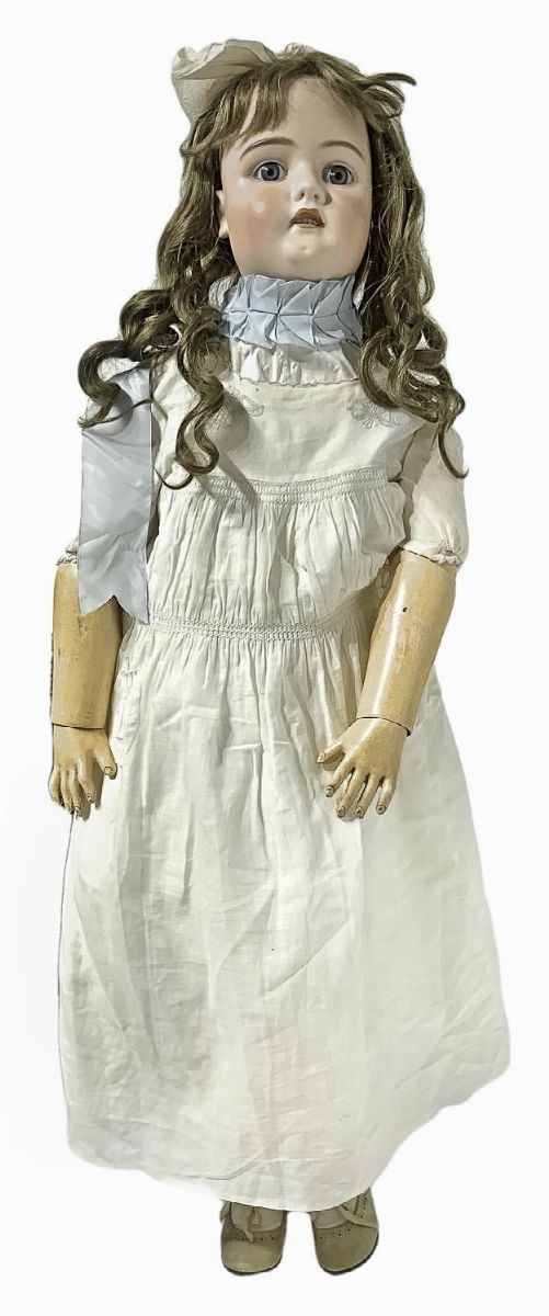 Bambola in biscuit e corpo in materiale composito, abito bianco con nastrino azzurro al collo, fiocchetto in testa, capelli veri, occhi fissi, n. 4 dentini, arti snodati, firma 16 478, 1900 ca., provenienza Germania, h cm 91
