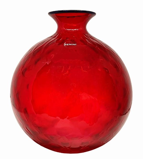 Production Venini, mod. Balloton. Glass vase in red garnet tones, machined surface quilted, signature engraved at the base. H 20 cm