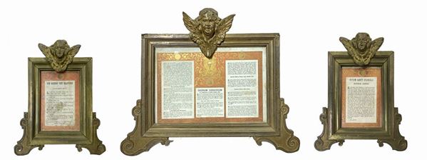 Trittico di cartagloriae in legno ricoperto da ottone con zefiri alati alla sommità, XX secolo. H cm 33x36; Le due piccole h cm 26x17. Presenza di difetti