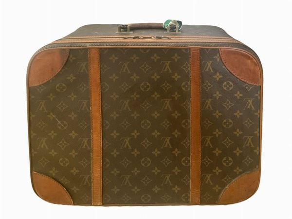 Produzione Louis Vuitton, valigia 48 ore, in vinile riportante monogrammi della manifattura. Anni &rsquo 60,Dettagli in cuoio color cognac e ottone.  ... 