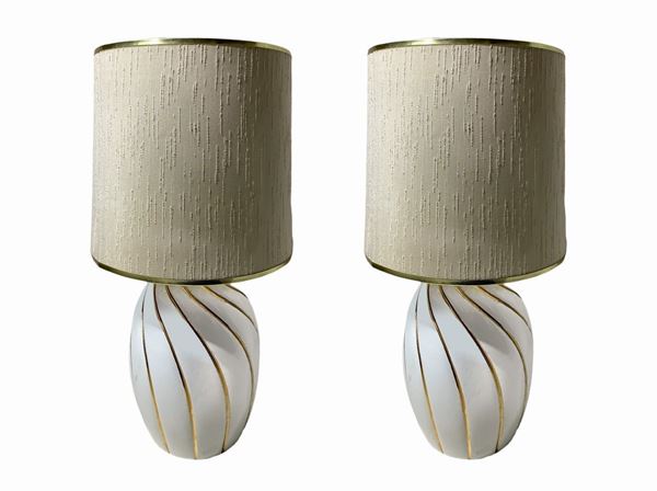 Pair of white porcelain lamps, prod Italian. Surface Showing Details in gold. Years â € 70s. ,
H cm 39. Diameter 22 cm