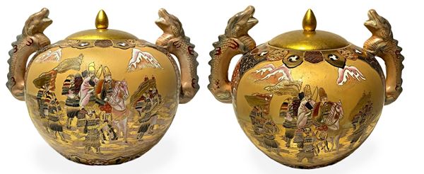 Coppia di potiche in porcellana con decorazioni in smalti e oro raffiguranti Samura, inizi XX secolo. H cm 29. Larghezza cm 40