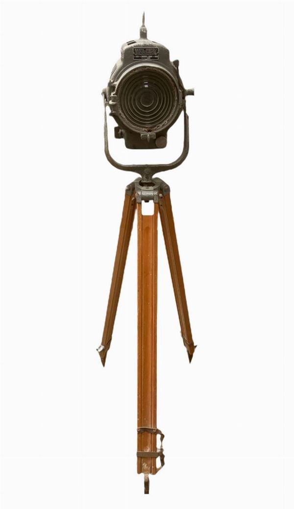 Produzione Dante Ruspoli. Proiettore in metallo con supporto treppiedi in legno regolabile. Mancanze e segni di uso da elettrificare.
H min cm 134, h ... 