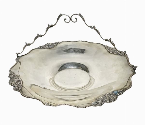 Centrotavola con manico in argento. H cm 7, con manico cm 17, larghezza cm.29. Decorazioni al bordo ed al manico gr. 648
H con manico cm 17, ... 