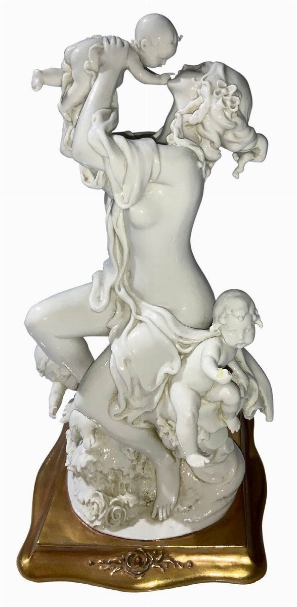White porcelain figurine with gold base depicting Maternity