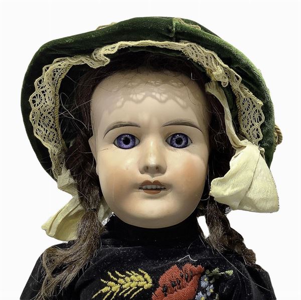 Doll in biscuit porcelain and body in composite material, dressed in black velvet with red strap and embroidered flowers, real hair, eyes, n. 5 teeth, jointed limbs, signing Mon Cheri L. P. Paris, about 1900, coming from France, h approx 61 cm, light stain in face