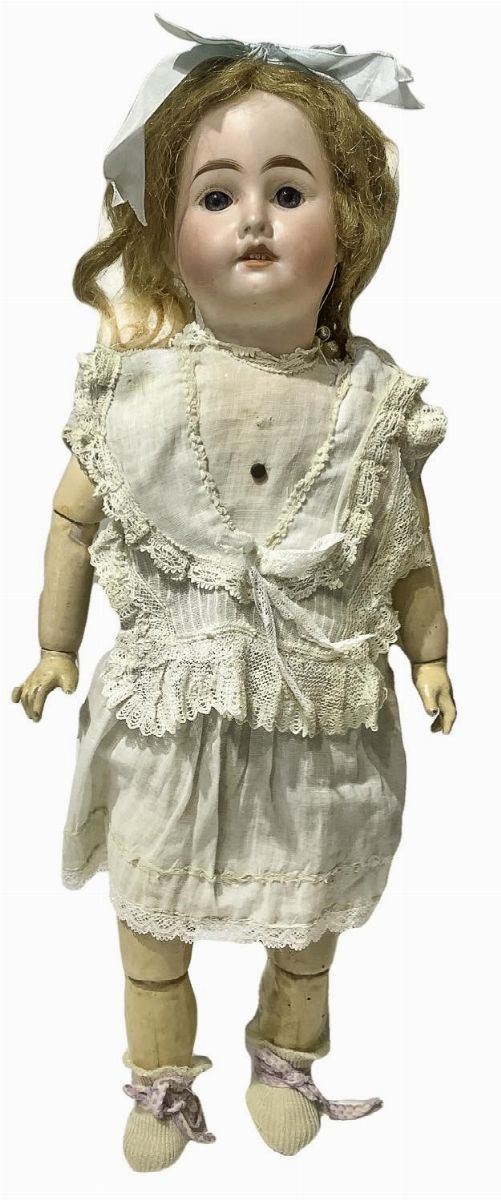 Bambola in biscuit e corpo in materiale composito, abito panna con bottoncino, capelli veri, occhi fissi, n. 4 dentini, arti snodati, 1900 ca., provenienza Parigi, appartenenza S.F.B.J.