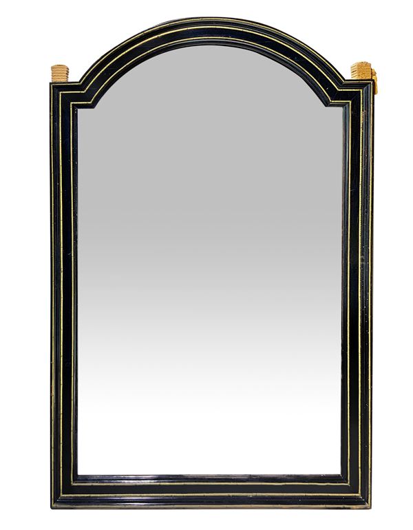 Specchiera in legno laccato nero e perfilato in ottone dorato di forma rettangolare con lato superiore ad arco.,Napoleone III, fine XIX secolo. Cm 186x120