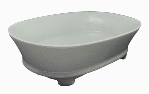 Hand-washing basin narcissus green in ceramic, likely Song Dynasty. The basin is oval, with the oblique and thin sides and four legs in the shape of cloud. It is entirely covered by a bright light green lacquering. During cooking, the piece was supported by 6 small underlying supports, which at the end of production remained creamy and without laccatura.H cm 7. Length 23.4 cm. Depth 16 cm.
