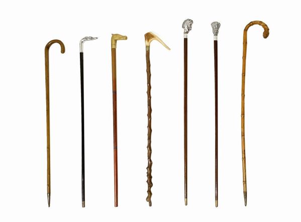Group of # 8 sticks. 3 with silver knob, one of them depicting the head of greyhound signed Gucci, one depicting a horse head in silver 925, with one knob in embossed silver wide-silver leaves 925. Two sticks with knobs in gilded bronze Egyptian style 1 with bone handle and two in the barrel.