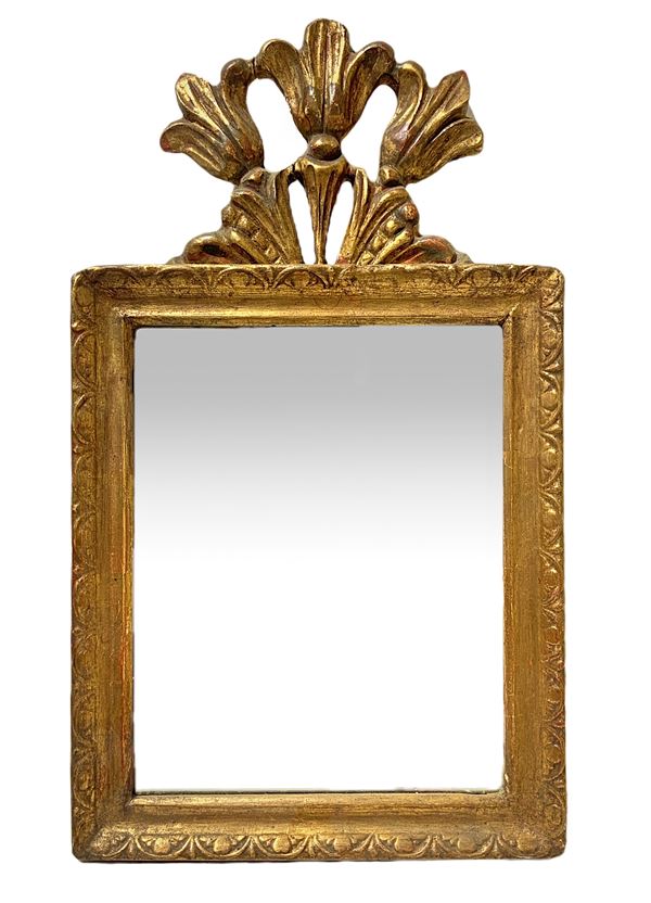 Piccola specchiera in legno dorato con cimasa, XIX secolo. Cm 46x26,5