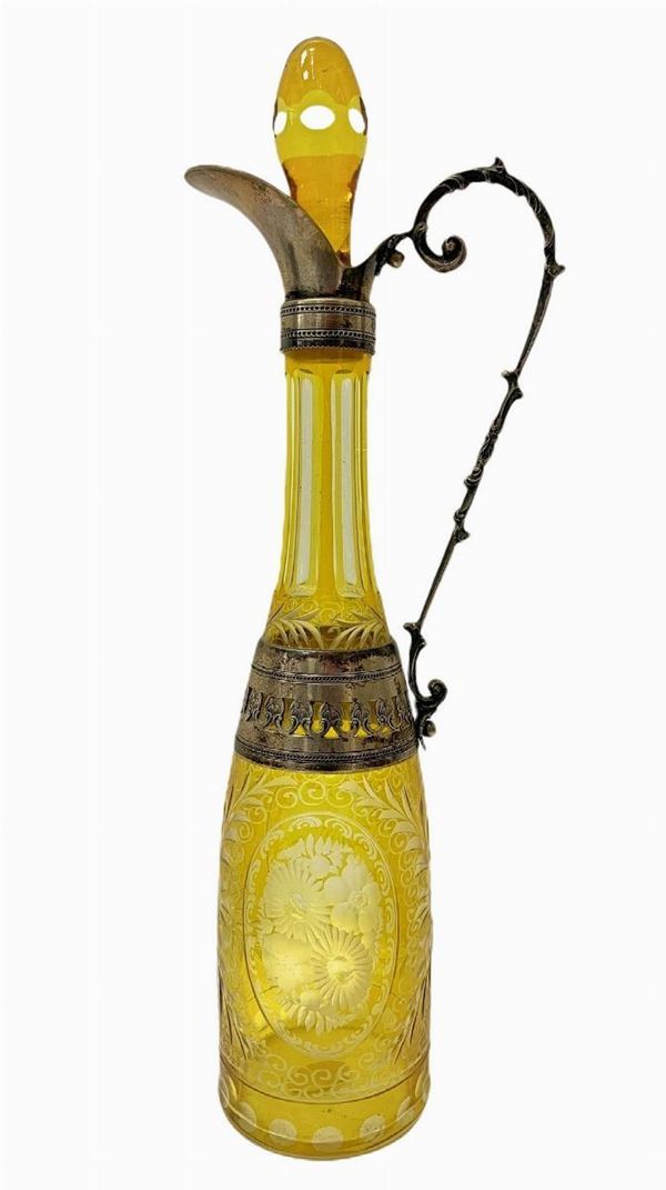 Bottiglia in vetro molato di Boemia nei toni del giallo con dettagli in argento. 