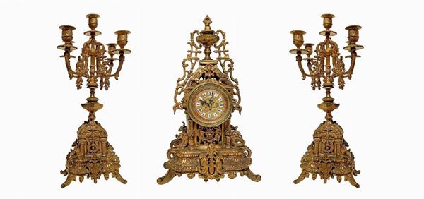 Trittico composto da coppia di candelieri e orologio in bronzo dorato. Candelieri a 5 luci H cm 44, orologio H cm 45.
Candelieri a 5 luci H cm 44, ... 