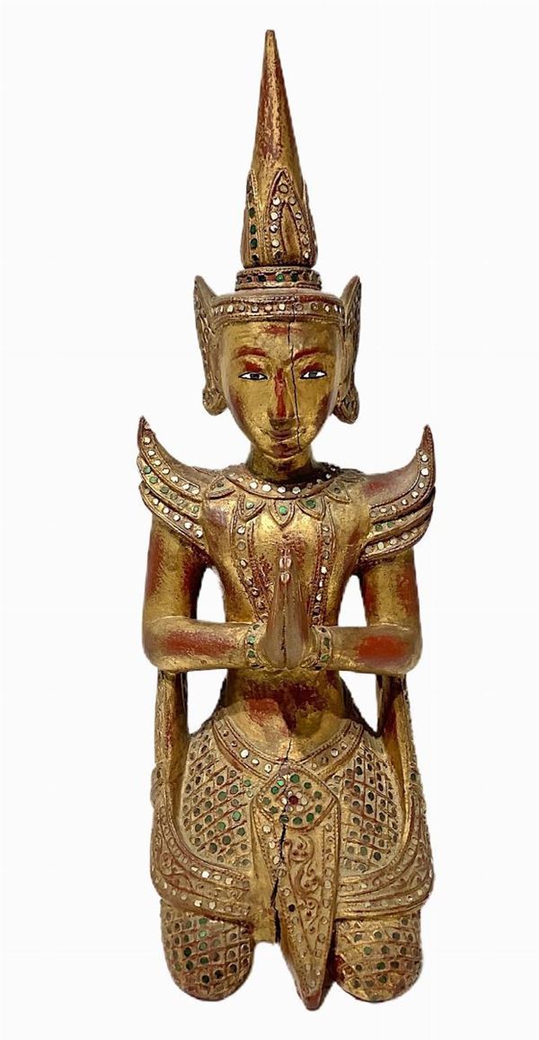 Scultura lignea, divinità orientale, inizi XX secolo. In legno dorato con applicazioni di vetri colorati. H cm 51