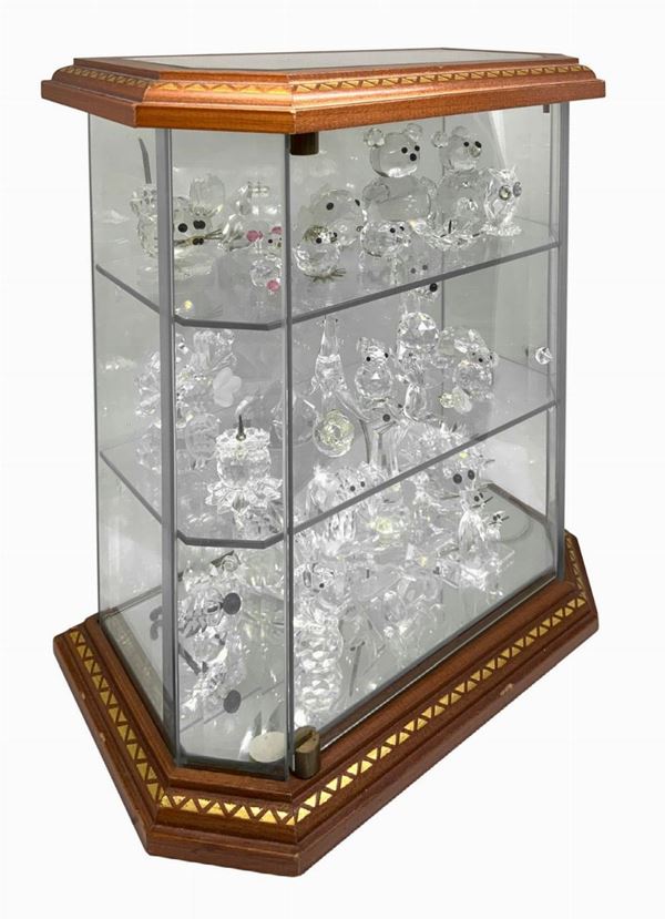 Bacheca contenente 28 figure in cristallo Swarovski. 
Cm 29 x 25 x 14,5.