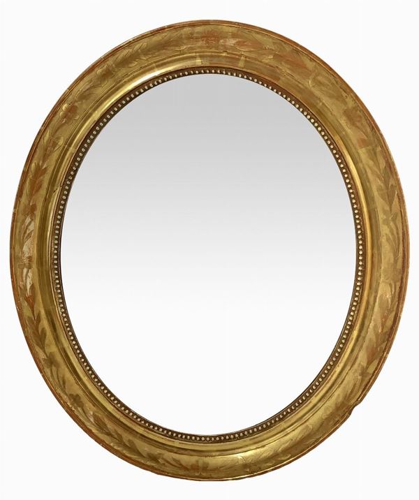 Specchiera ovale con cornice dorata a foglia oro. Fine XIX secolo.  Cm 70x80