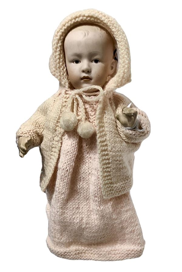 Bambola in biscuit e corpo in materiale composito, abito in maglia rosa, occhi dipinti, arti curvi, 1900 ca., provenienza Germania, " Bebe caractère", h. cm 24, 