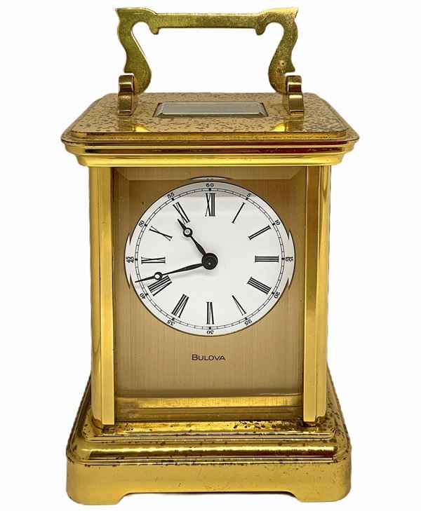 Bulova - Bulova, travel alarm clock in box with gold metal structure and bevelled glass, manual winding. H cm 12x8,5. Depth cm 7. Since overhaul

