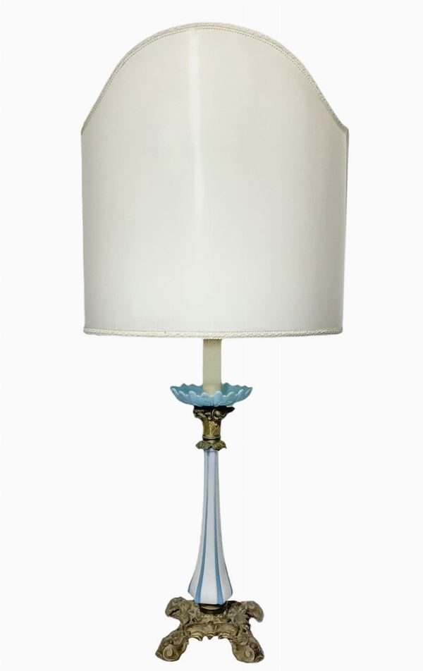 Lume in vetro opaline di colore bianco e celeste, base in bronzo dorato con ventola. Inizi XX secolo. H cm 100 con paralume, cm 59 senza paralume.