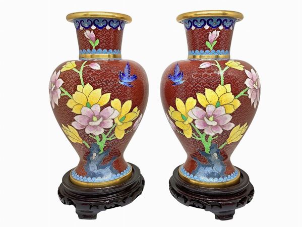 Coppia di vasi in metallo con decorazione floreale con base in legno. 