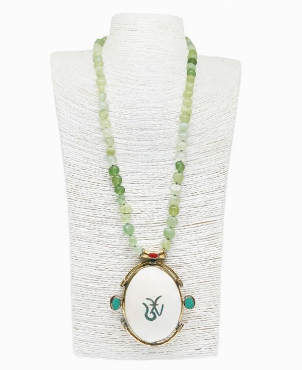Necklace in non-polished aventurine. Central pendant in shell surrounded by golden metal and enamels

80 cm length